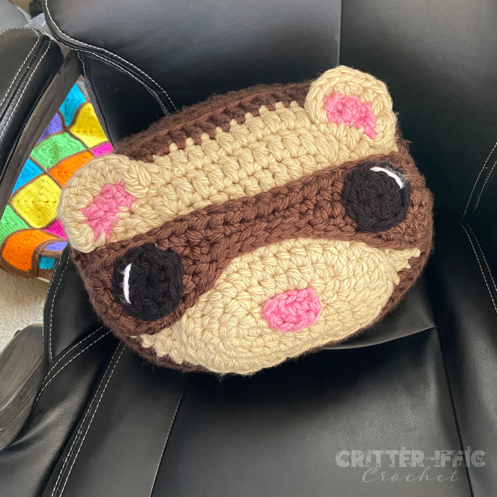 Ferret pillow sitting on a leather computer chair